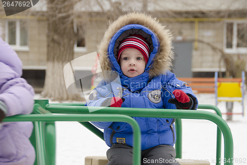 Image of little girl with fear of riding on merry-go-round
