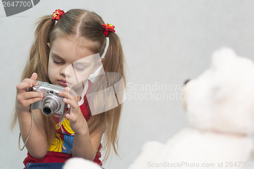 Image of Girl takes photo of Teddy digital camera