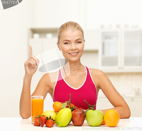 Image of woman with juice and fruits holding finger up