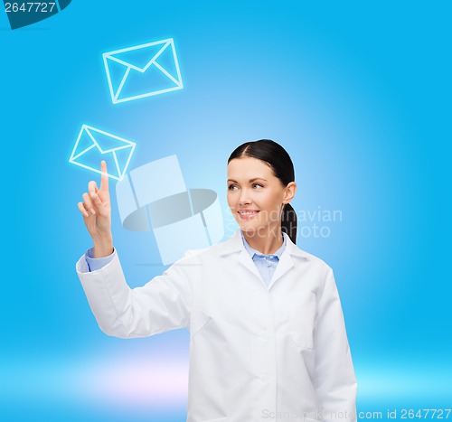 Image of smiling female doctor pointing to envelope