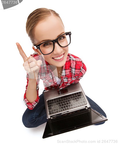 Image of smiling teenage girl in eyeglasses with laptop