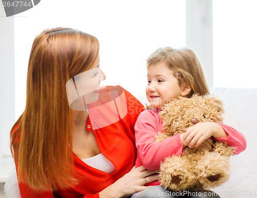 Image of happy mother and child with teddy bear at home