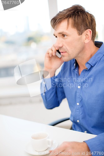 Image of buisnessman with cell phone and cup of coffee