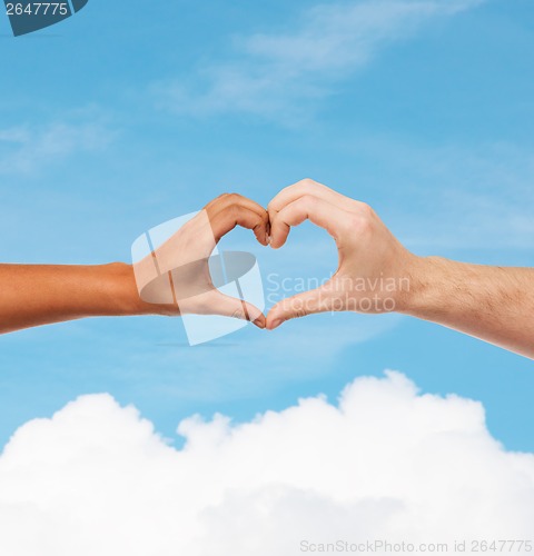 Image of woman and man hands showing heart shape