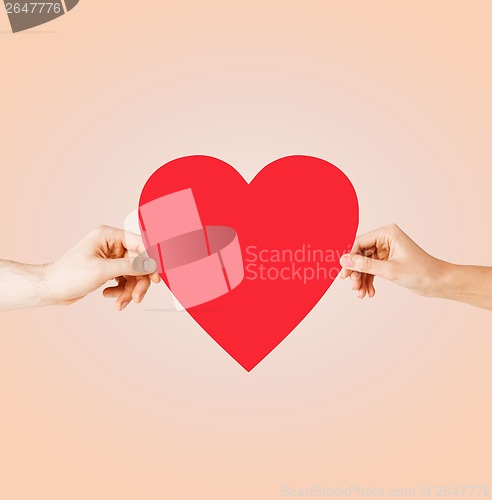 Image of couple hands holding red heart