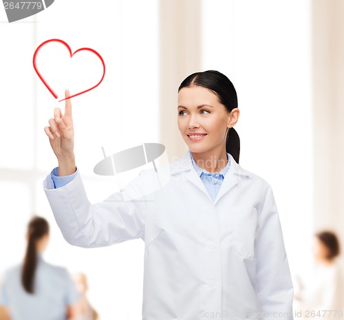 Image of smiling female doctor pointing to heart