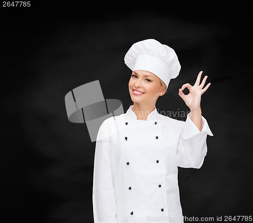 Image of smiling female chef showing ok hand sign