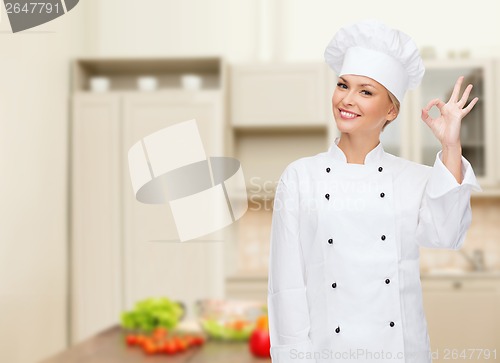 Image of smiling female chef showing ok hand sign