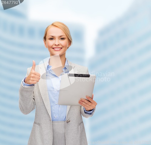 Image of smiling woman with tablet pc showing thumbs up