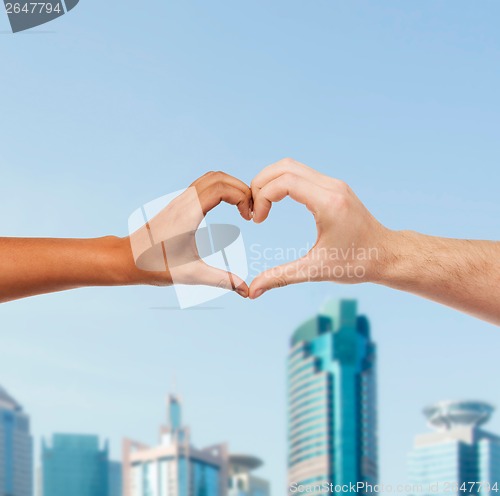 Image of woman and man hands showing heart shape