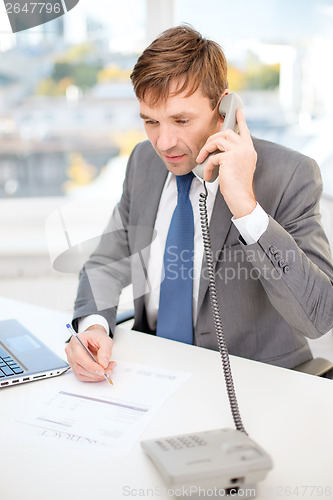 Image of businessman with laptop computer and phone