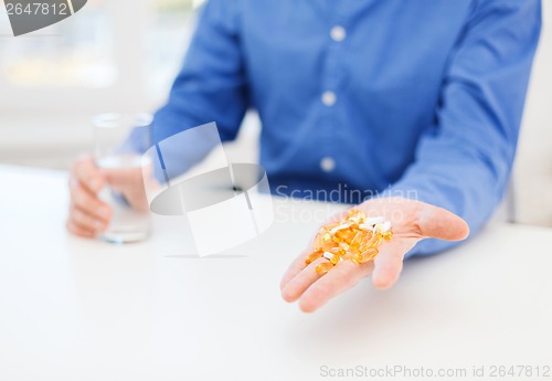 Image of close up of male hand showing lot of pills