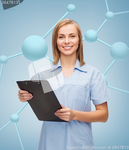 Image of smiling female doctor or nurse with clipboard