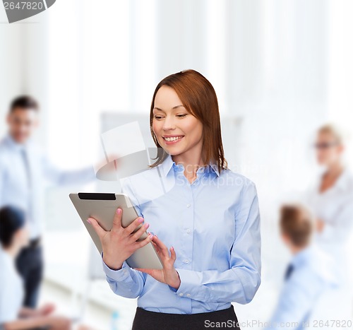 Image of smiling woman looking at tablet pc at office