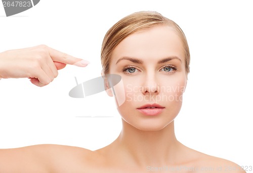 Image of woman pointing at her face