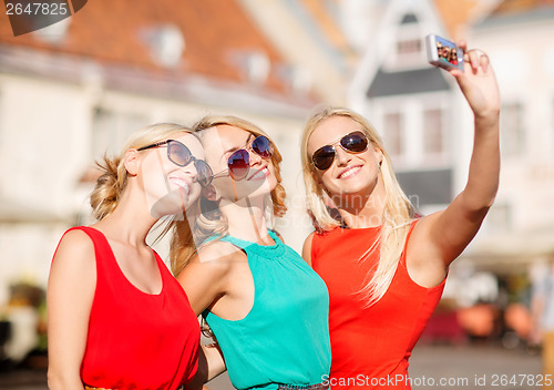 Image of three beautiful girls taking picture in the city