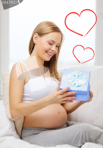 Image of smiling pregnant woman opening gift box