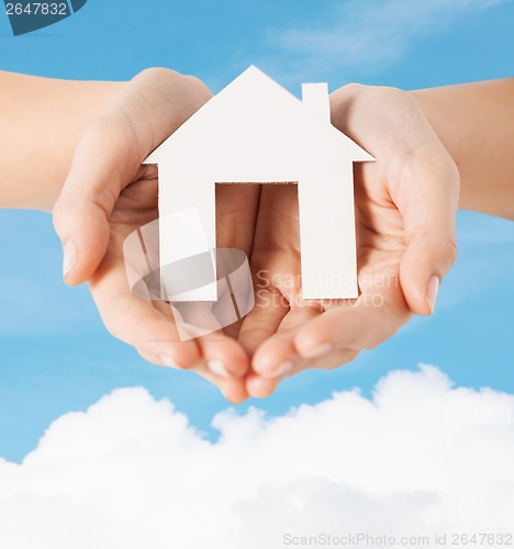 Image of female hands holding paper house