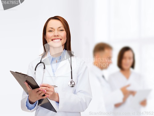 Image of smiling female doctor with clipboard