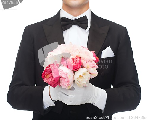 Image of man in tail-coat with flower bouquet