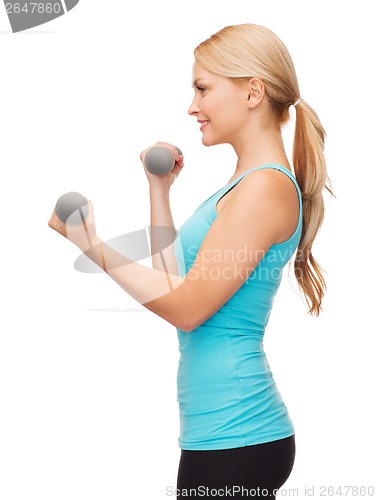 Image of young sporty woman with light dumbbells