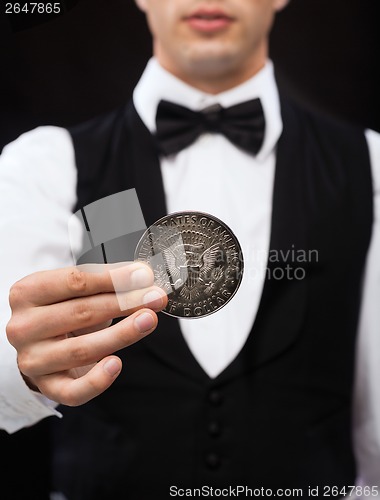 Image of dealer holding half dollar coin