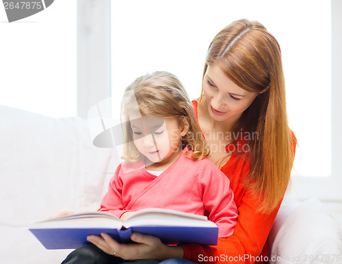 Image of happy mother and daughter with book