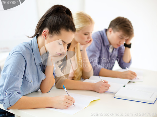 Image of tired students with notebooks at school