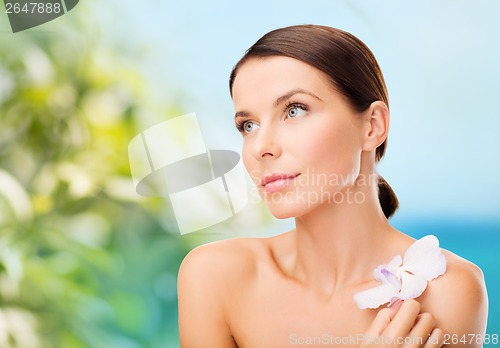 Image of relaxed woman with orhid flower