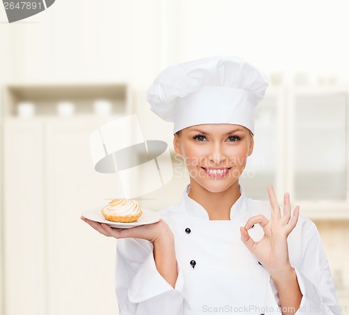 Image of smiling female chef with cake on plate