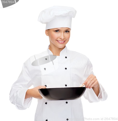 Image of smiling female chef with pan and spoon