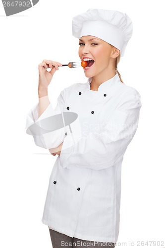 Image of female chef, cook or baker with fork and tomato