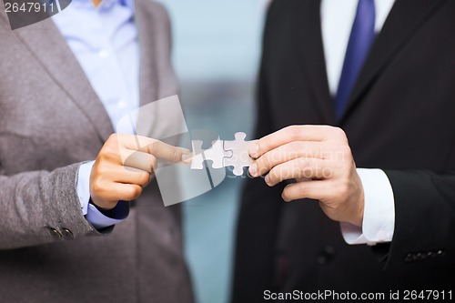 Image of businessman and businesswoman with puzzle pieces