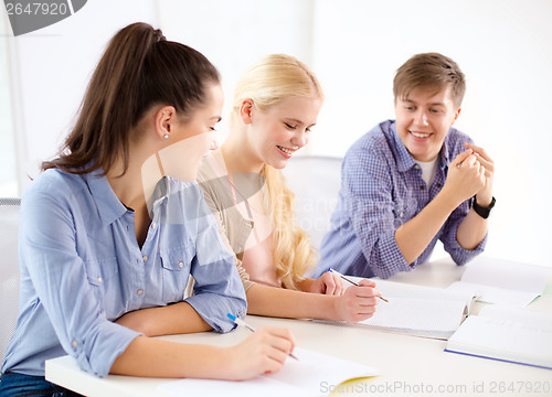 Image of smiling students with notebooks at school