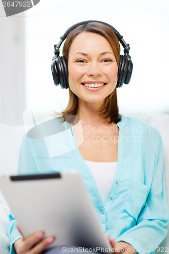 Image of smiling woman with tablet pc and headphones