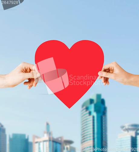 Image of couple hands holding red heart