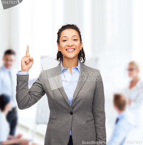 Image of smiling businesswoman with her finger up at office