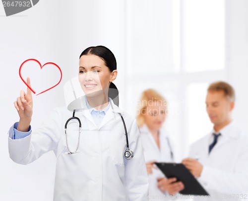 Image of smiling female doctor pointing to heart