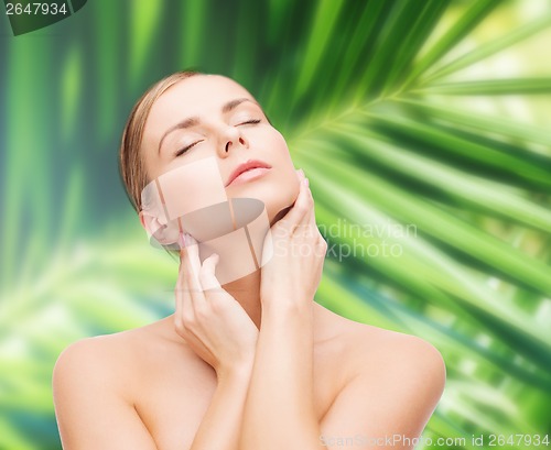 Image of beautiful woman touching her face with closed eyes