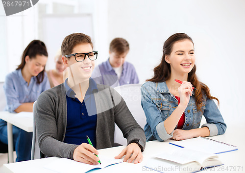 Image of smiling students with notebooks at school