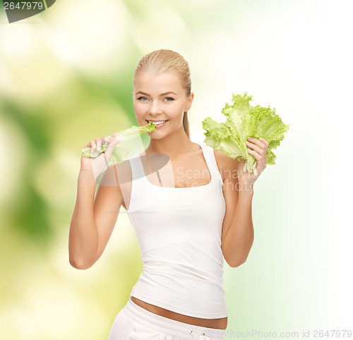 Image of smiling woman biting lettuce