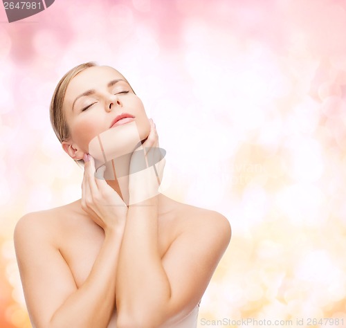 Image of beautiful woman touching her face with closed eyes