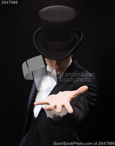 Image of magician holding something on palm of his hand