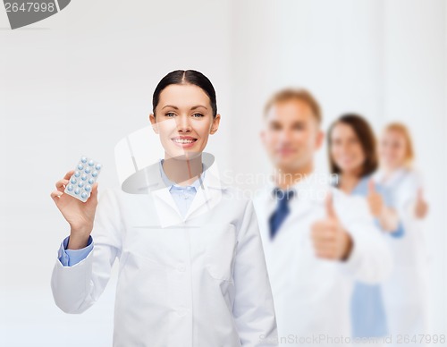 Image of smiling female doctor with pills