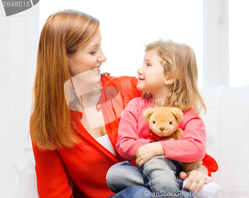 Image of happy mother and child with teddy bear at home