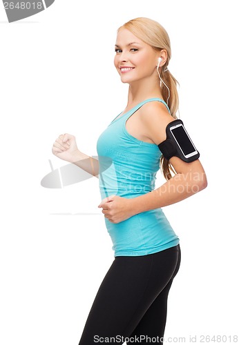 Image of sporty woman running with smartphone and earphones