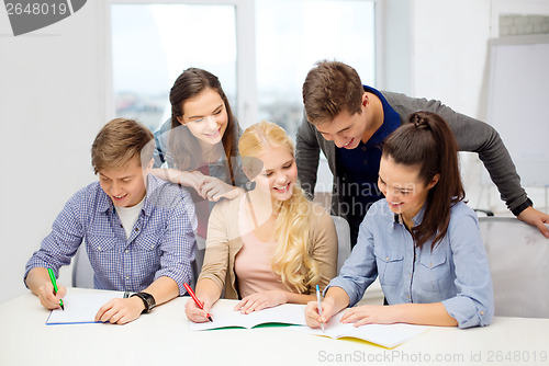 Image of smiling students with notebooks at school