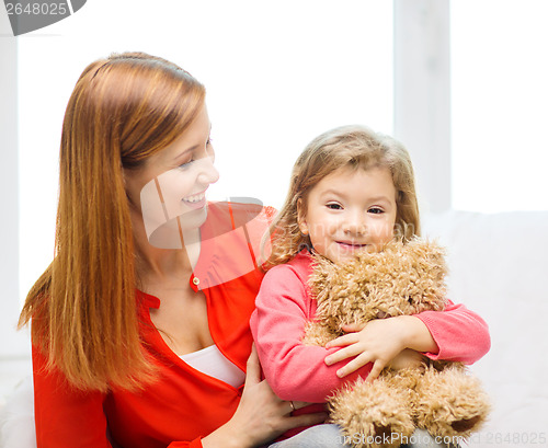 Image of happy mother and child with teddy bear at home
