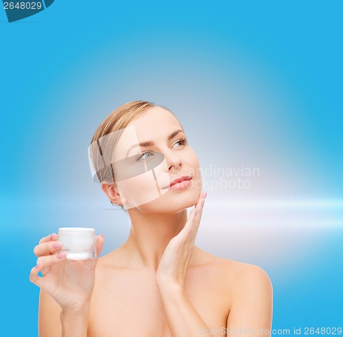 Image of woman applying cream on her skin