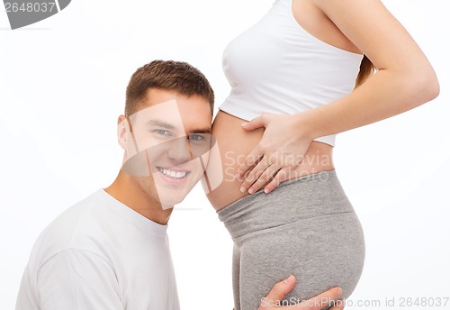 Image of happy father listening belly of his pregnant wife